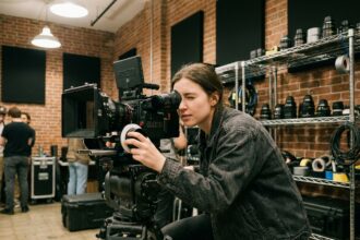 Étudiante en école de cinéma opérant une caméra professionnelle dans un studio de formation audiovisuelle